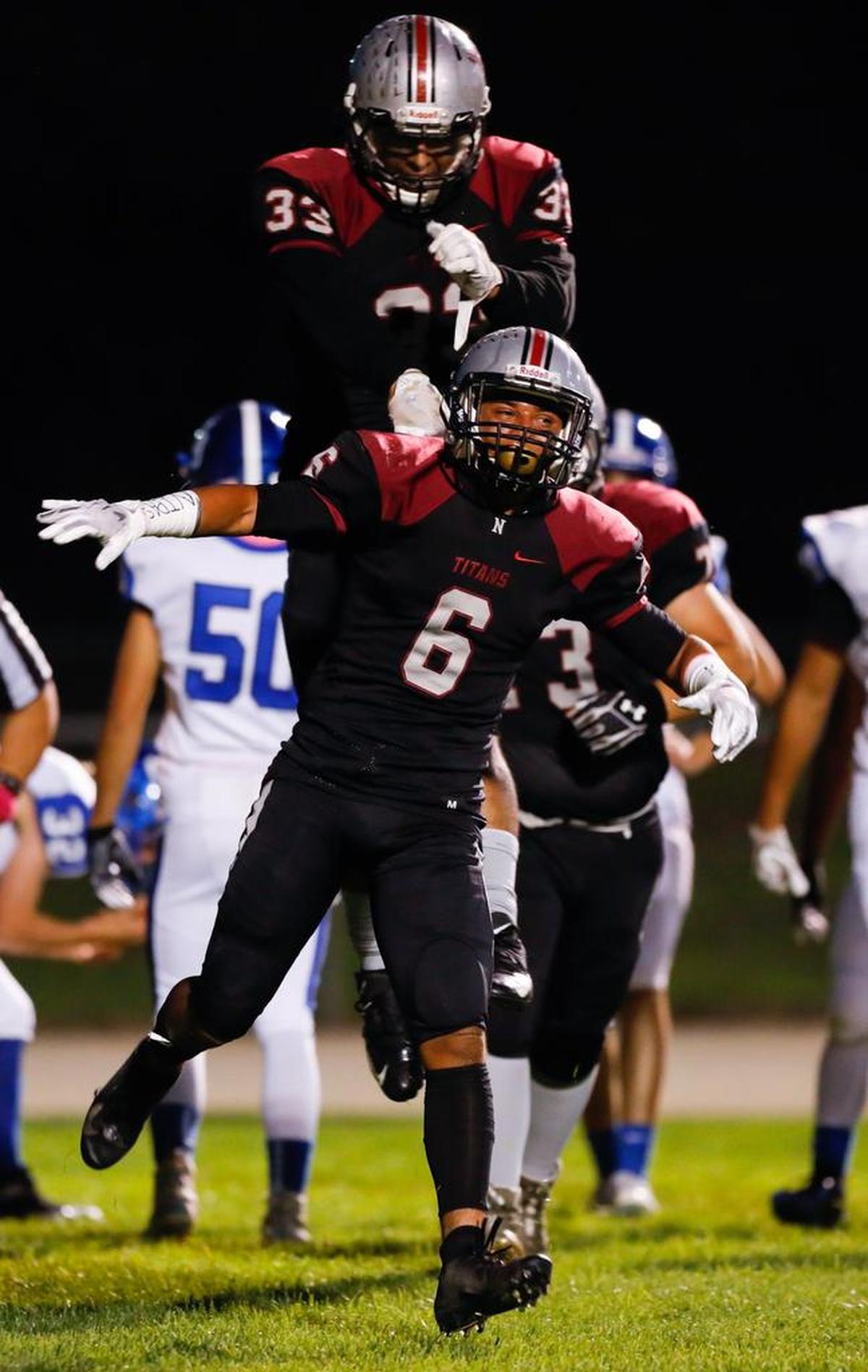 Ricky Iniguez gets a pat on the back from Carmelo Hernandez after scoring for the Nipomo High School football team Friday night against Morro Bay.