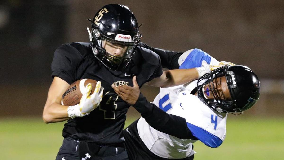 San Luis Obispo High School running back Anthony Arroyo fends off a Hanford West defender in a non-conference game Friday night.