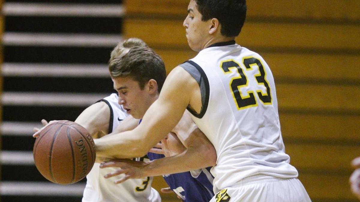 Mark Kirschner left and Alex Chai foul Kalvin Hilliard of Moro Bay as he tries to advance out of the backcourt. San Luis Obispo hosted Morro Bay in a high school boy's basketball game.