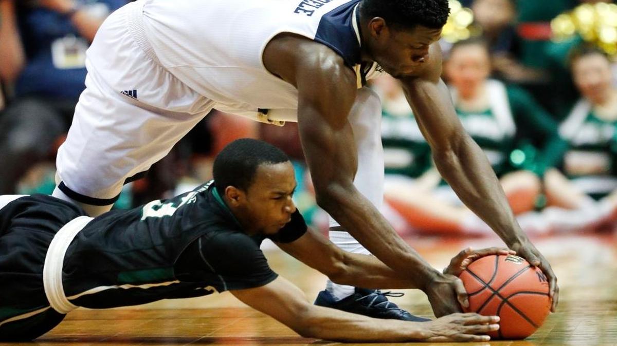 UC Davis’ J.T. Adenrele, top, and Cal Poly’s Donovan Fields fight for a loose ball during the first round of the Big West Tournament last week in Anaheim.