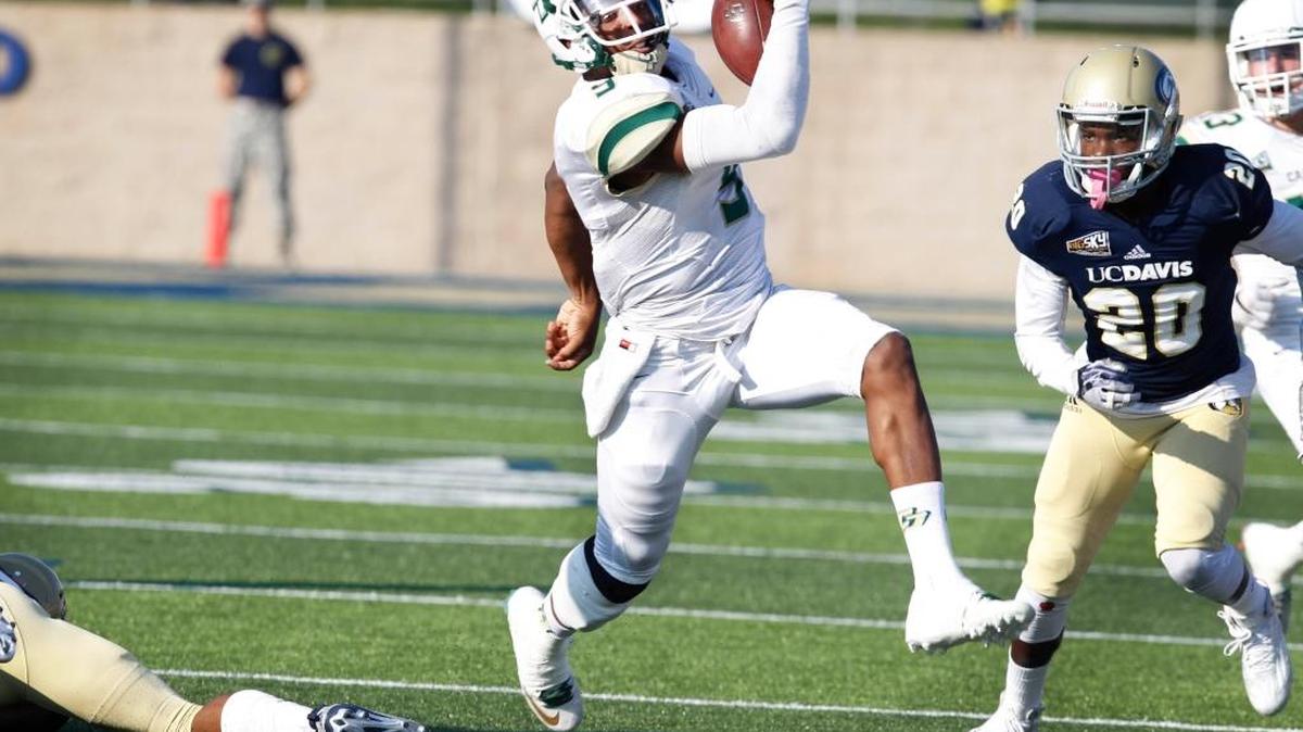 Cal Poly quarterback Chris Brown (9) breaks loose for a gain against UC Davis defenders during the first half the Mustangs’ win Saturday in Davis.