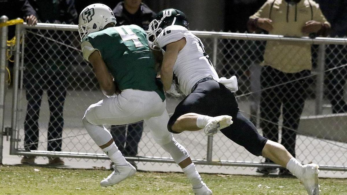 Cal Poly’s Kyle Lewis (4) makes a touchdown catch in the second quarter over Sacramento State’s Austin Clark (10) during Saturday night’s game at Cal Poly.
