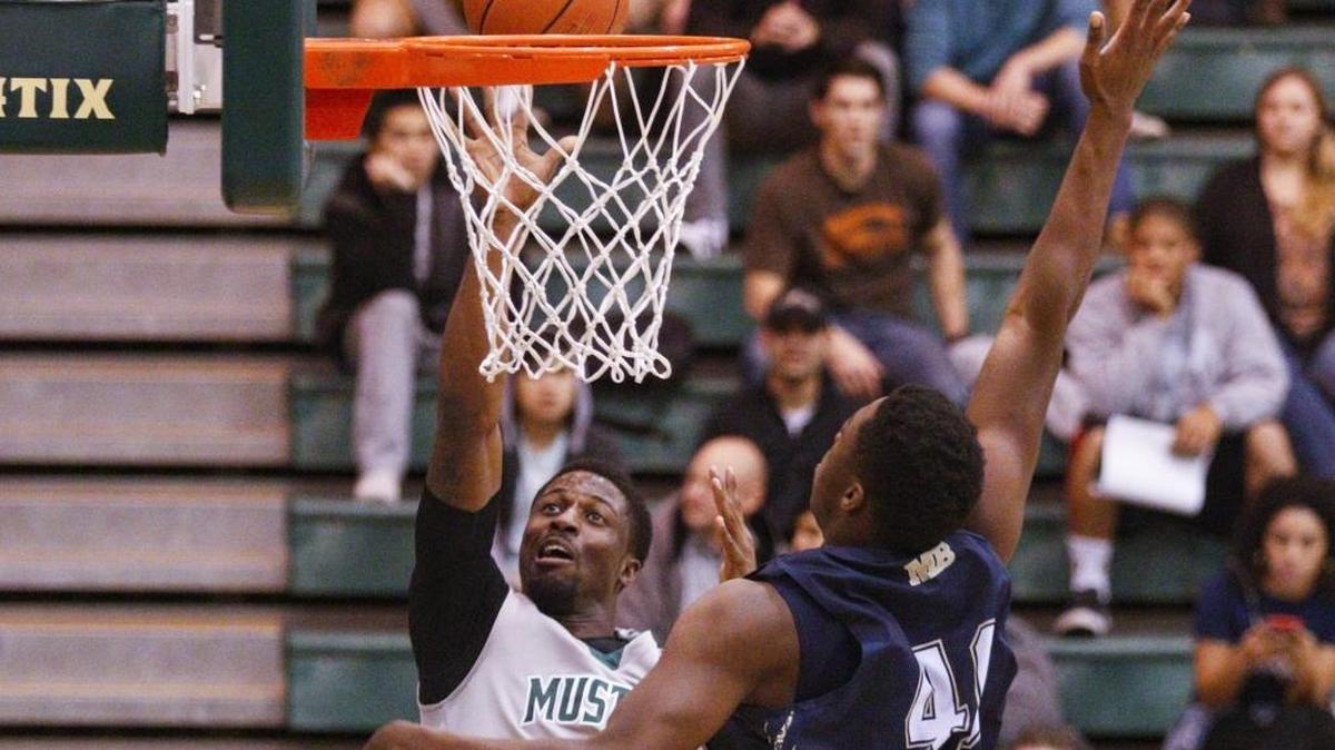 David Nwaba sinks a basket over Julien Ducree. Cal Poly hosted Cal State Monterey Bay for a men’s basketball game.