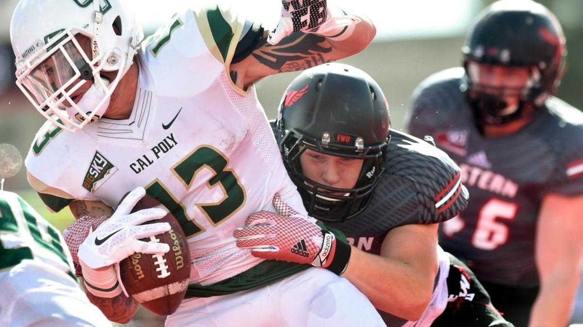 Cal Poly slot back DJ Peluso (13) is brought down by Eastern Washington during the first half of the Mustangs’ game at Roos Field in Cheney, Wash.