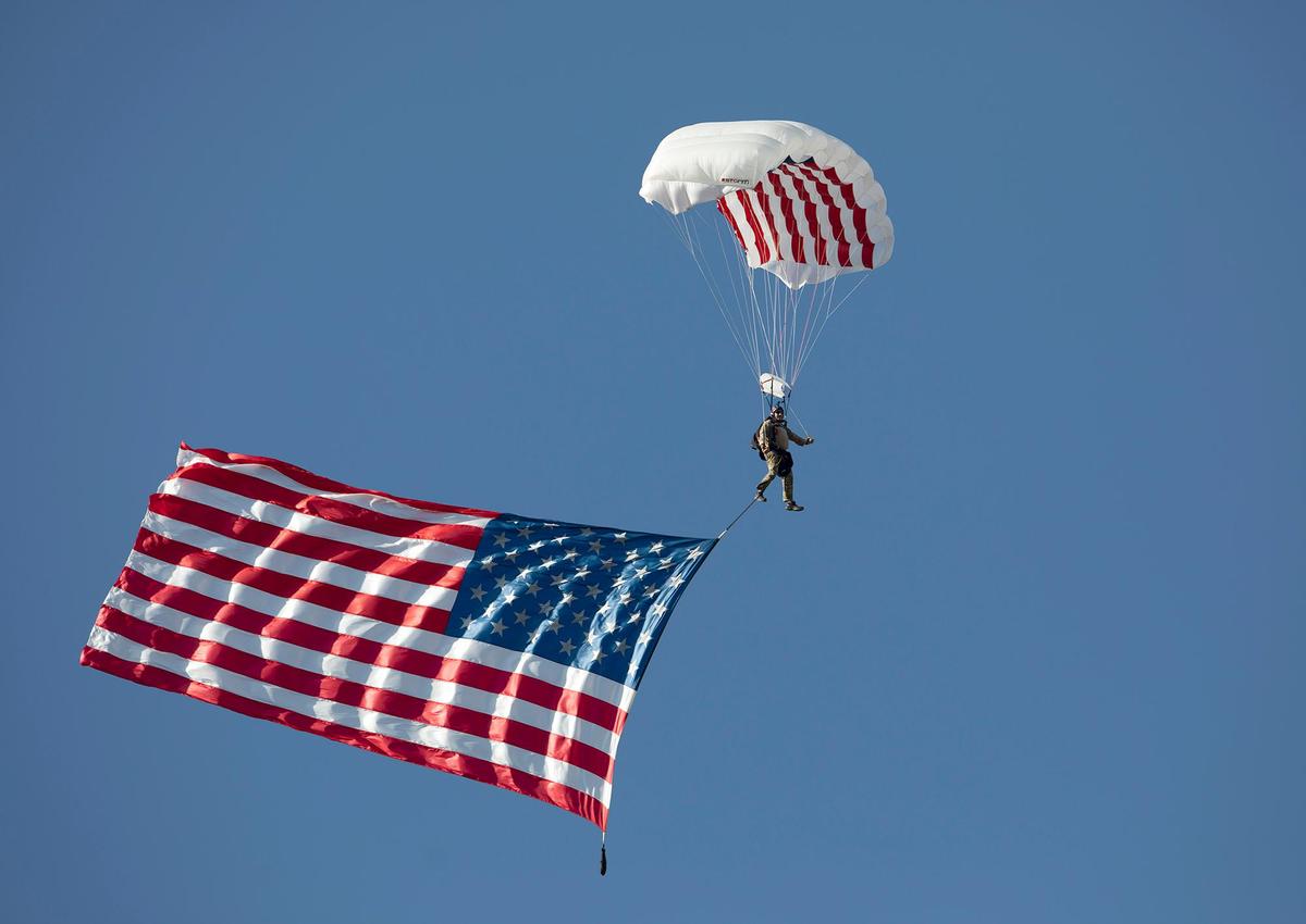 A skydiver flies the American flag down to the football field at Spanos Stadium ahead of Cal Poly’s game against on Saturday, Sept. 18, 2021.