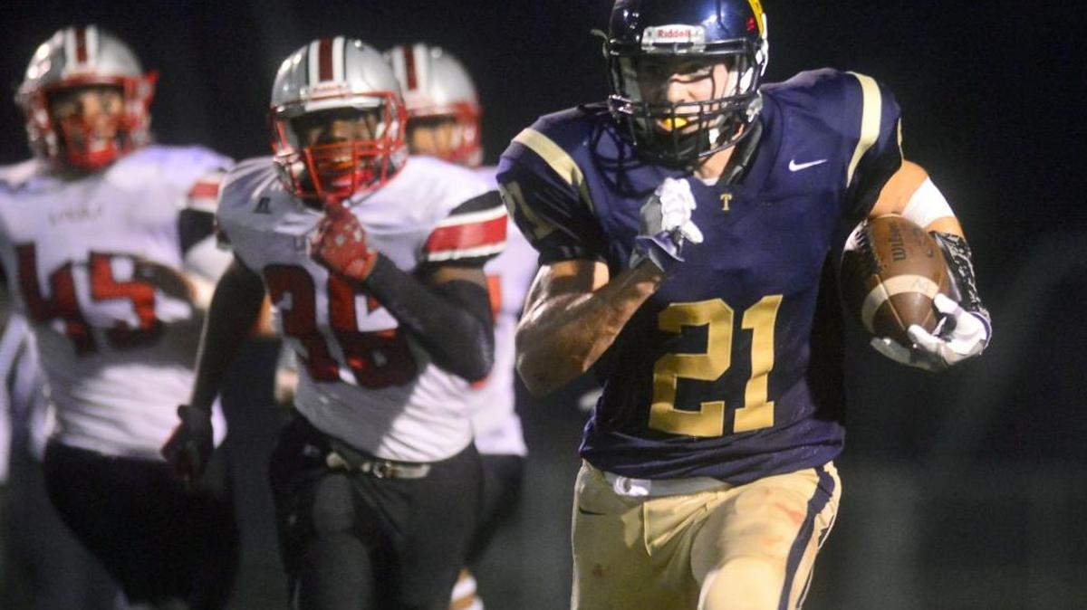 Turlock running back Dustin Grein (21) runs off tackle during a game between Turlock and Lincoln at Turlock High School in Turlock California on November 10, 2016. Grein signed with Cal Poly football Wednesday and is expected to play linebacker.
