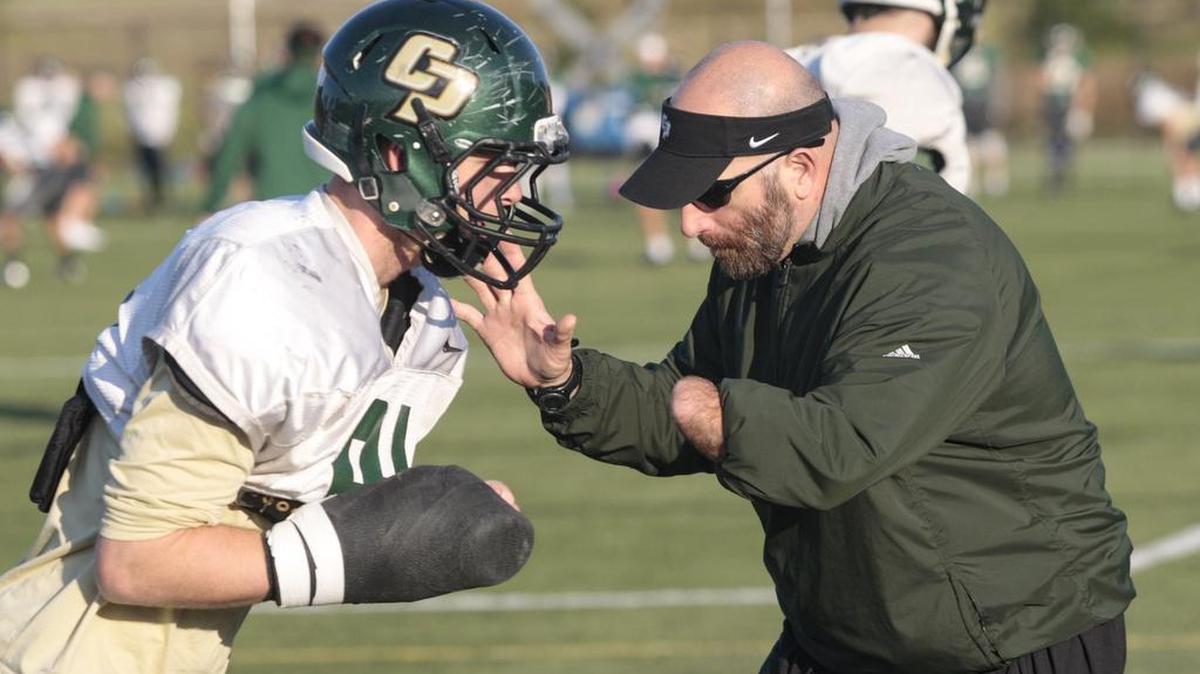 Cal Poly defensive line coach Payam Saadat is starting his third stint with the Mustangs this spring. He works with Colin Dzubnar during a drill at practice earlier this week.