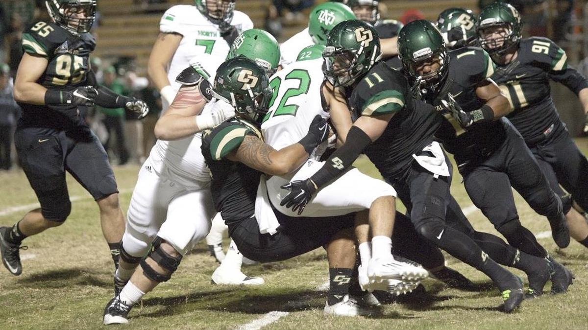 Cal Poly’s defense gang tackles North Dakota’s John Santiago (22) during the fourth quarter of the Mustangs’ 48-21 loss Saturday night at Alex G. Spanos Stadium.