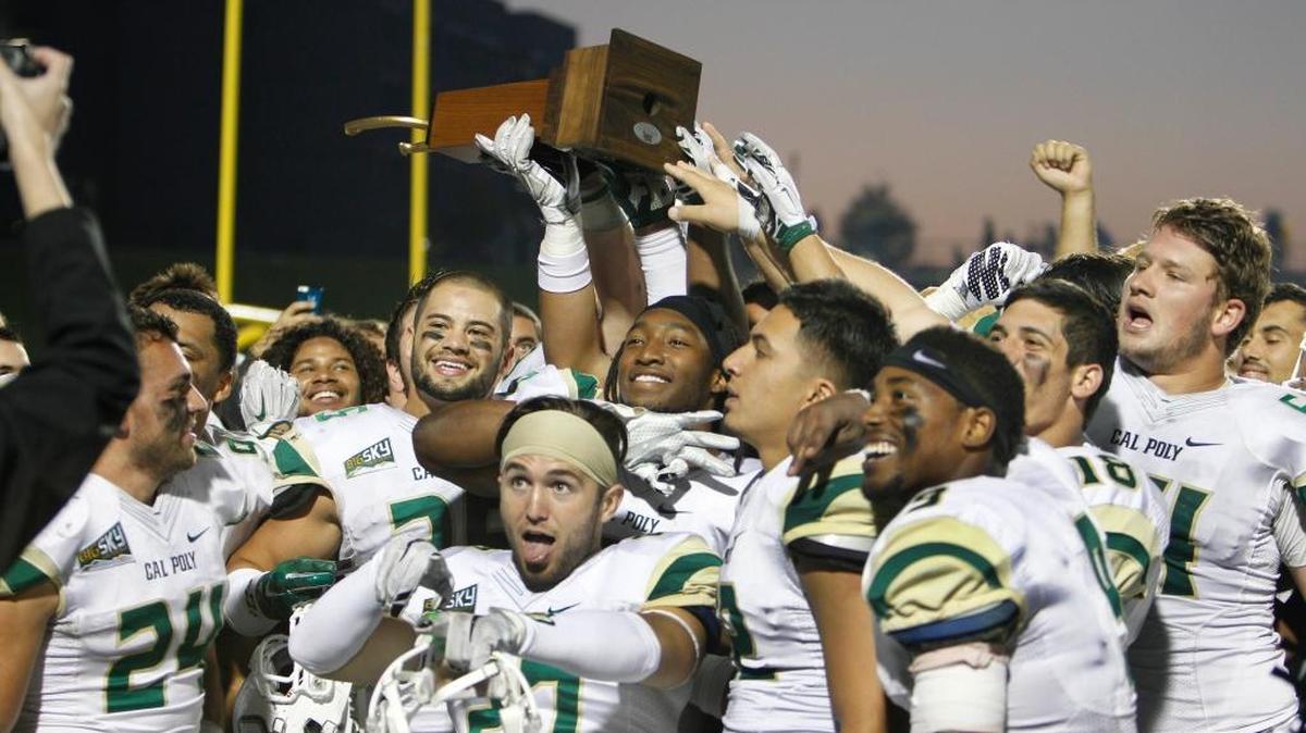 Cal Poly players celebrate their victory with the Golden Horseshoe trophy after beating UC Davis 55-38 on Saturday in Davis.