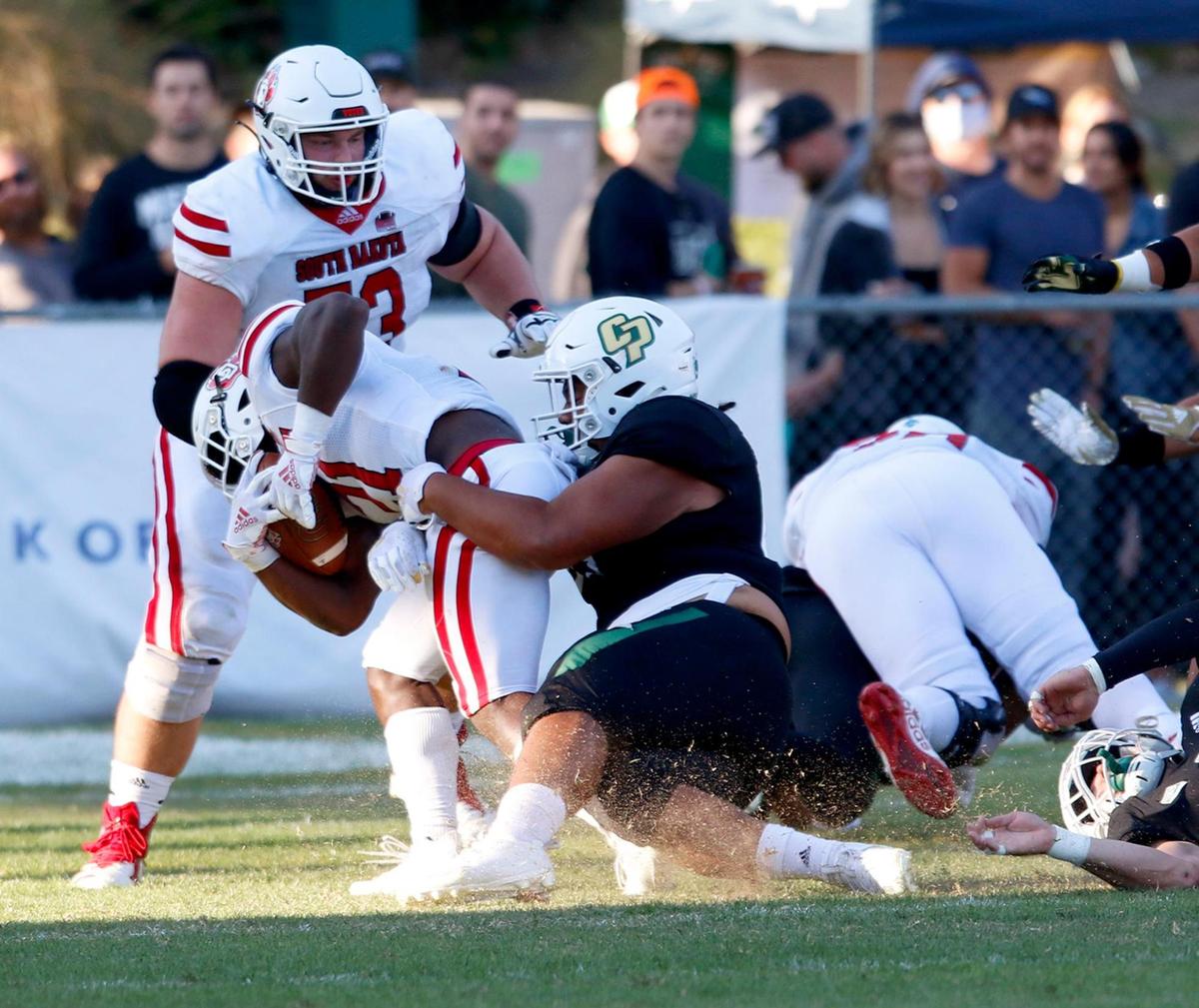 Cal Poly’s Josh Ngaluafe (99) takes down South Dakota’s (21) Mike Mansaray as Mansaray scores a touchdown in Cal Poly’s 48-14 loss to South Dakota on Saturday, Sept. 18, 2021.