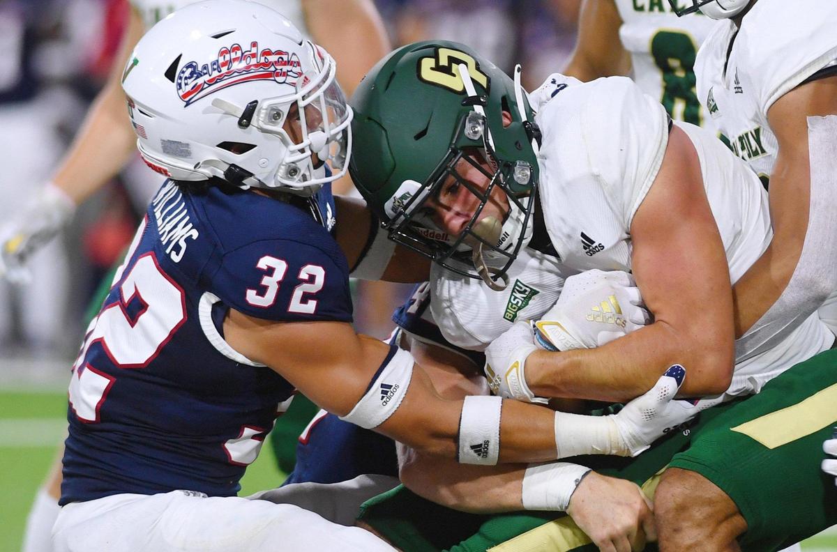 Fresno State’s Evan WIlliams, left, helps bring down Cal Poly’s Giancarlo Woods, center, Saturday, Sept. 11, 2021 in Fresno.
