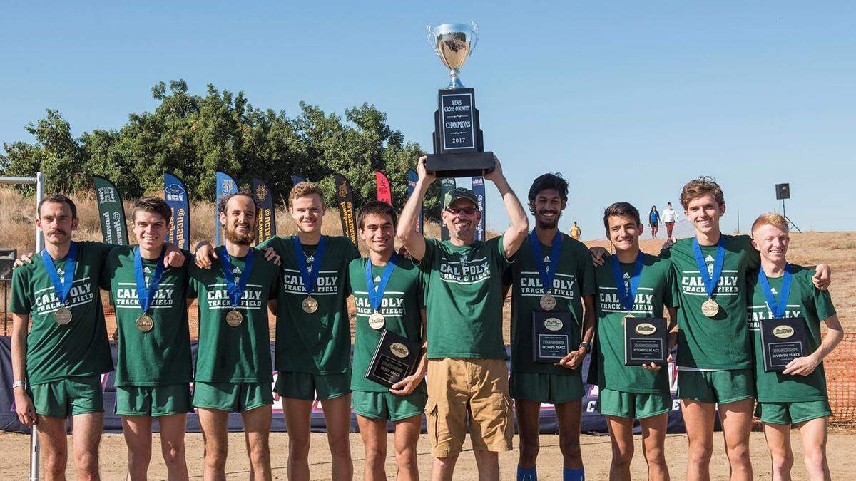 Mark Conover (middle) celebrates the 2017 Cal Poly Men’s Cross Country championship. Conover was Cal Poly’s Director of Track & Field and Cross Country for more than 13 years and a coach of the Mustangs for 25 seasons overall. He died on April 6.