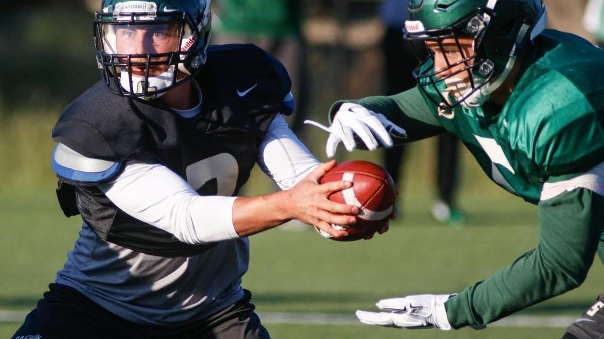 Quartback Dano Graves hands off to fullback Joe Protheroe at Cal Poly Football practice.