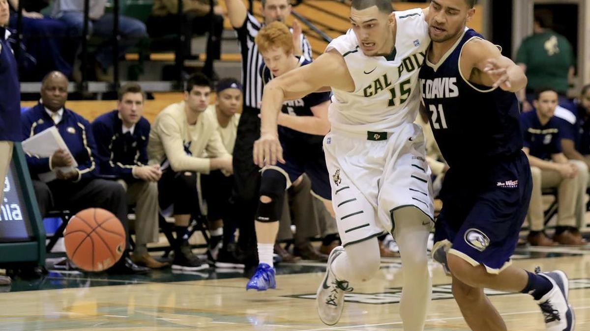 Cal Poly’s Josh Martin (15) battles for the ball with UC Davis’ Josh Fox (21) during the Mustangs 58-53 victory on Thursday night at Mott Athletics Center.