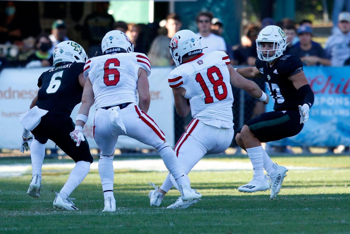 Cal Poy’s Xavier Oliphant (6) and Matthew Stuppiello (33) get ready to take down South Dakota’s quarterback Carson Camp (18). Cal Poly lost to South Dakota 48-14 in its 2021 home opener on Saturday, Sept. 18.