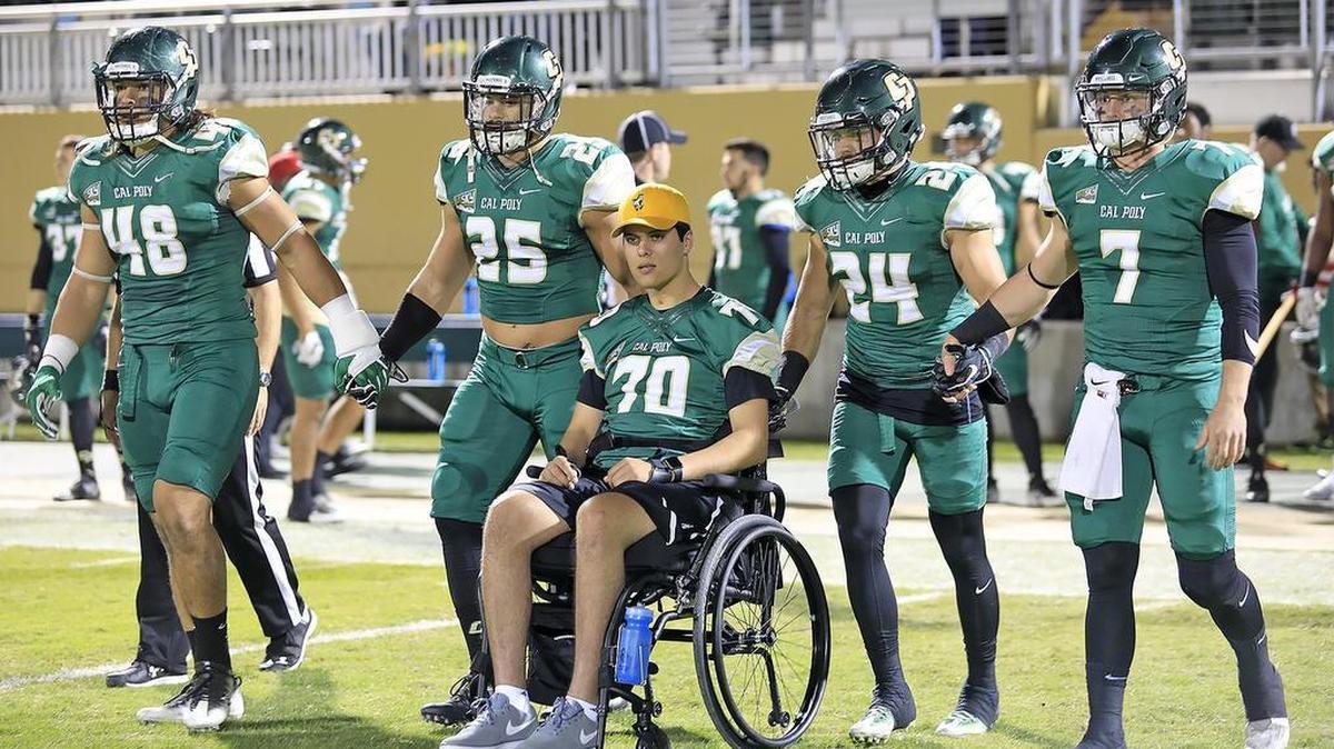 Former Cal Poly preferred walk-on Jake Javier, center, joins the Mustangs’ captains during the pregame coin toss Saturday night at Alex G. Spanos Stadium. Javier was paralyzed from the chest down in a swimming accident in June. He was honored at Cal Poly’s last game of the regular season.