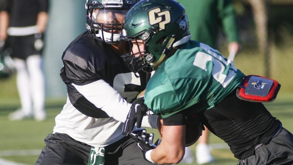 Khaleel Jenkins hands off to Alex Suchesk at Cal Poly football practice Wednesday morning.