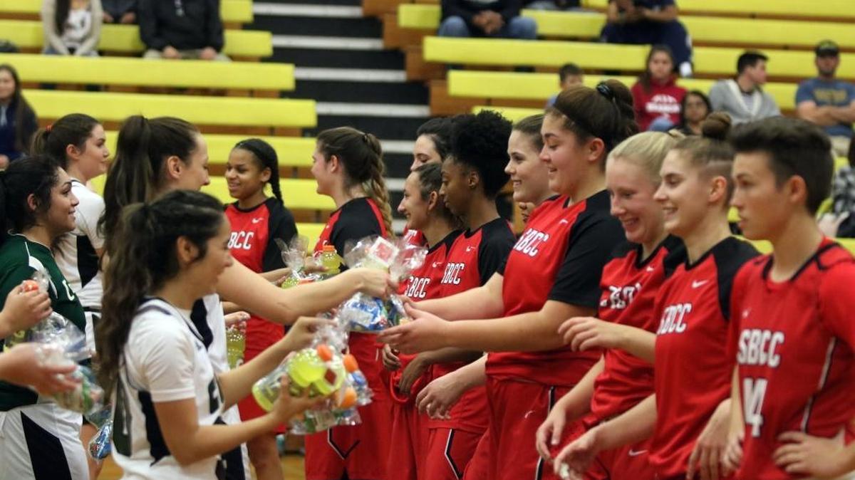 The Cuesta College women’s basketball team (left) presents the Santa Barbara City College team with a small gift back and messages of support following the deadly mudslides that occurred just a few miles from the Santa Barbara campus.