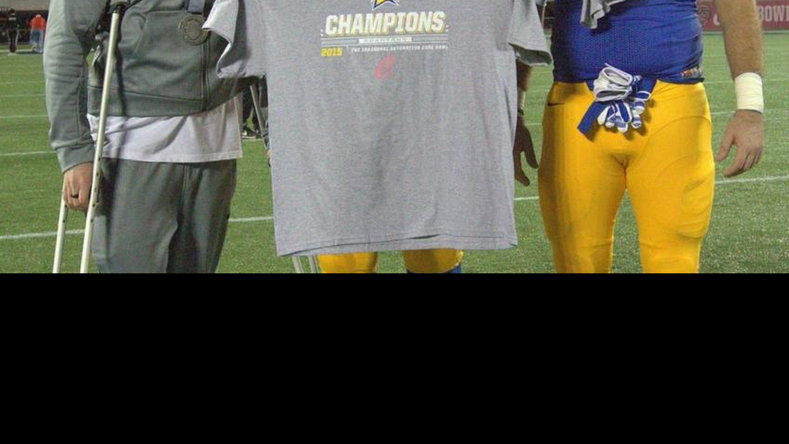 Josh Oliver, center, poses with Billy Freeman, left, and Matt Spadaro after the Spartans won the Cure Bowl on Dec. 19 in Orlando, Fla.