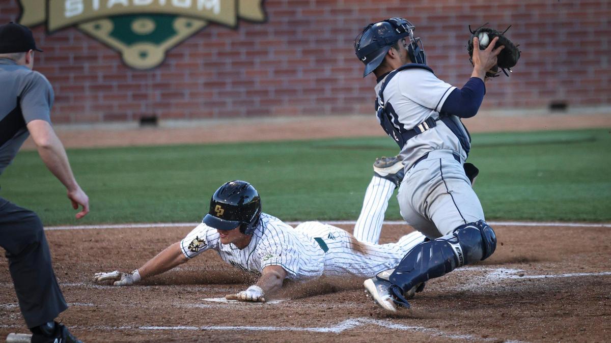 Ryan Fenn scores on a slide ahead of throw as Emiliano Gonzalez fields. Cal Poly hosted UC San Diego seen here on April 4, 2025.