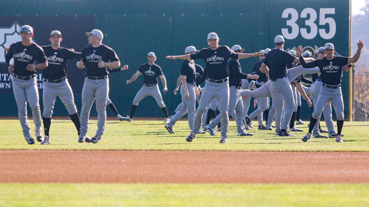 Cal Poly baseball players warm up with stretching drills at Baggett Stadium in San Luis Obispo earlier this season. Its spring season has been suspended, along with other Big West sports.