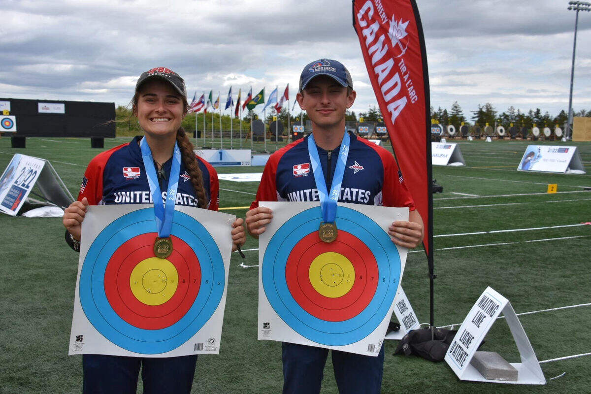 Bella Otter and Tyler Heritage celebrate their U21 mixed team gold by showing off their marks from the competition in Halifax, Nova Scotia, in June 2022.