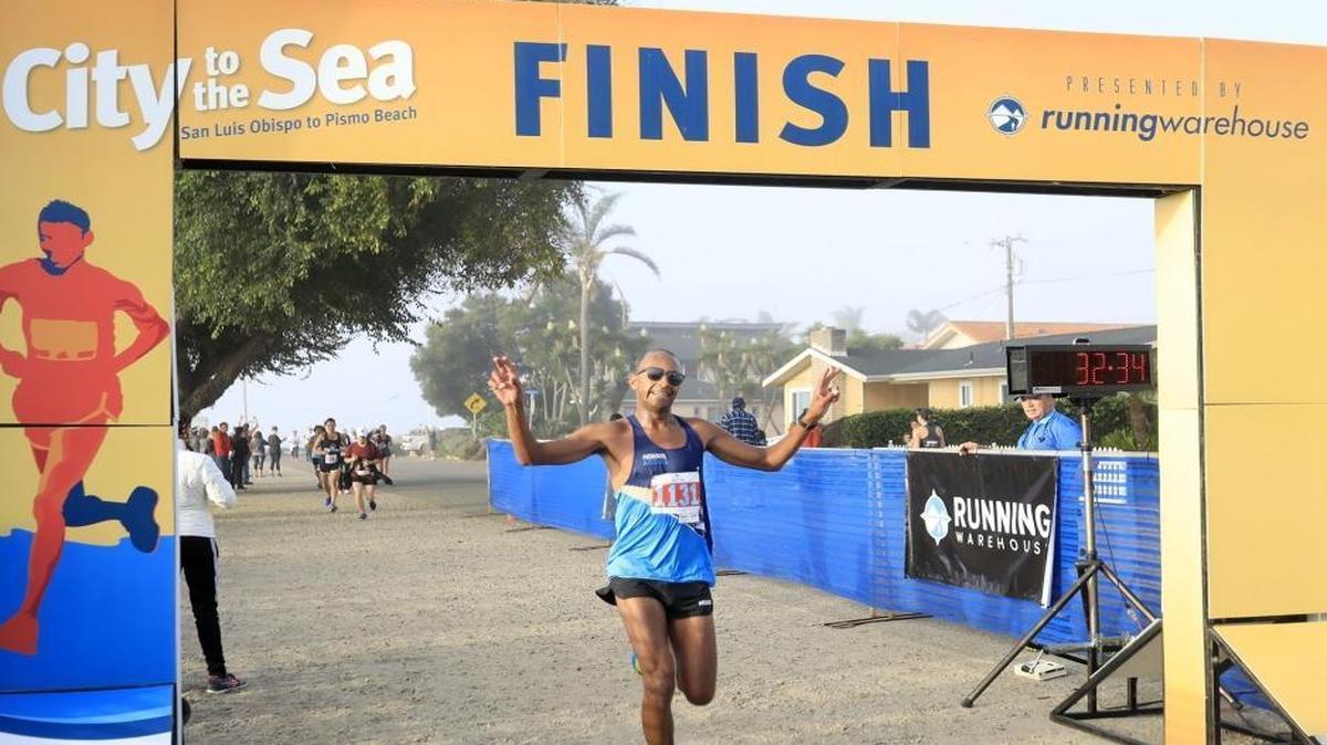 San Luis Obispo’s Phillip Reid crosses the finish line first in the the 22nd annual City to the Sea Half Marathon, which started in downtown San Luis Obispo, wound through town and ends in Pismo Beach, on Sunday.