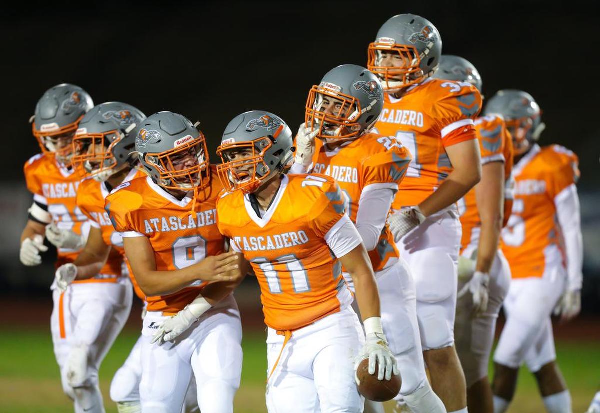 Atascadero High School players celebrate an interception by Tyler Chapman (11).