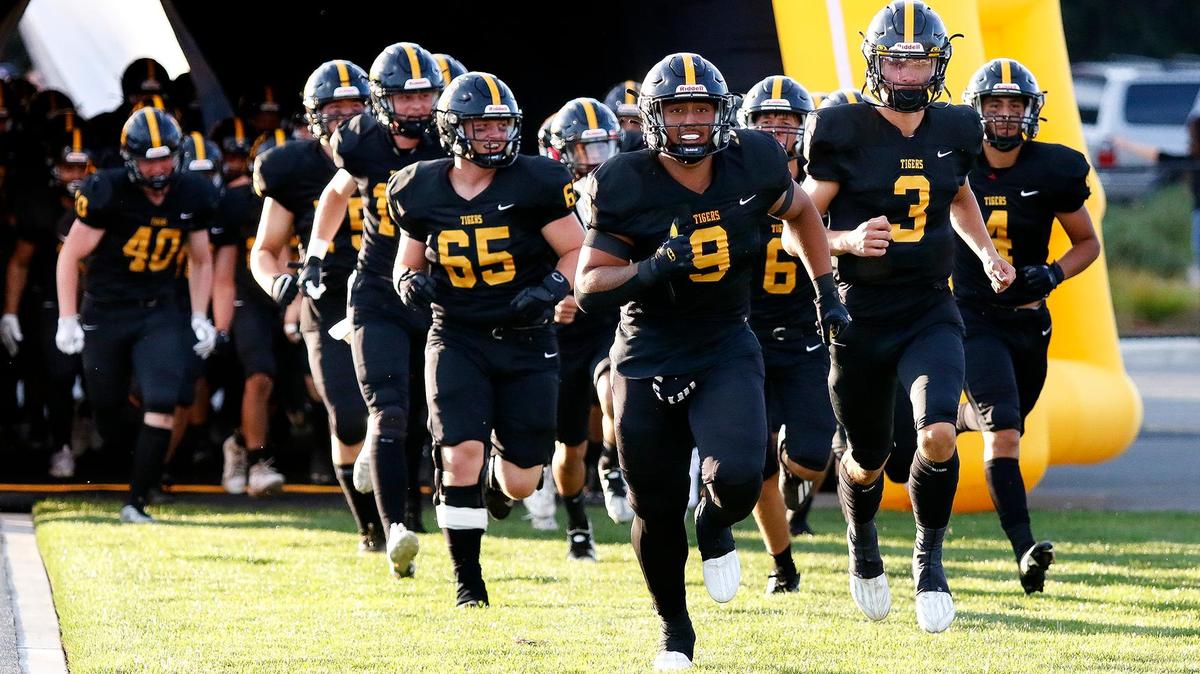 The SLO Tigers burst out of the helmet with Isiah Hernandez (9) leading the way. San Luis Obispo beat Nipomo 38-7 in a nonleague game at San Luis Obispo High School’s Holt Field stadium, Aug. 18, 2023.