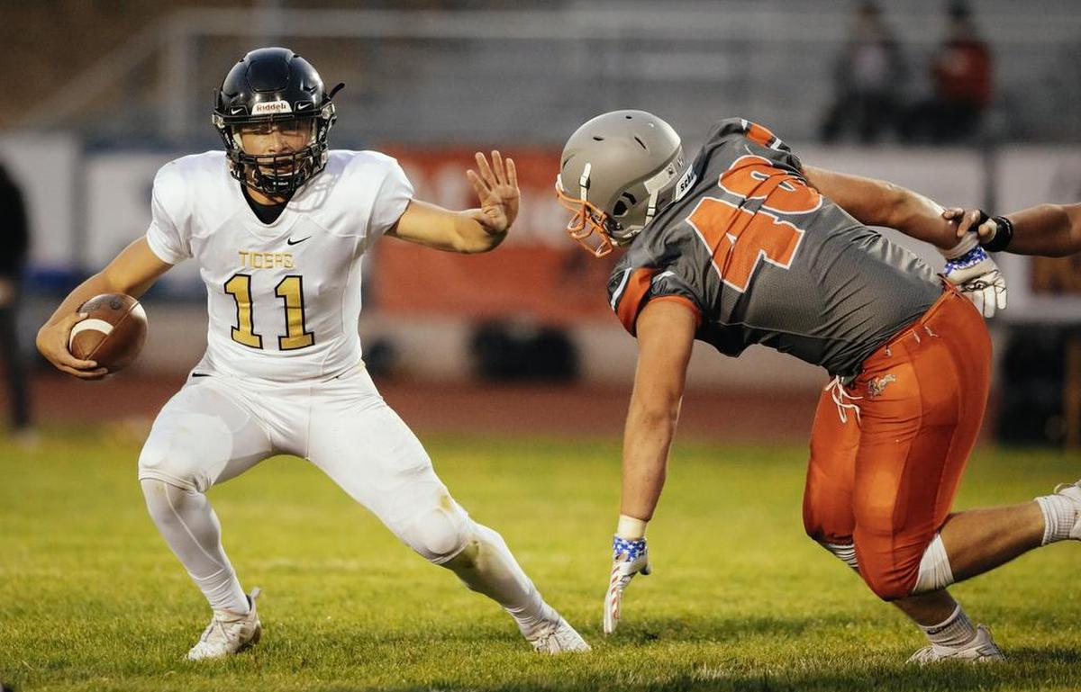San Luis Obispo High School quarterback Emilio Corona fends off an Atascadero’s Seth Robescotti in SLO High’s 21-14 non-conference win in 2018 in Atascadero, California