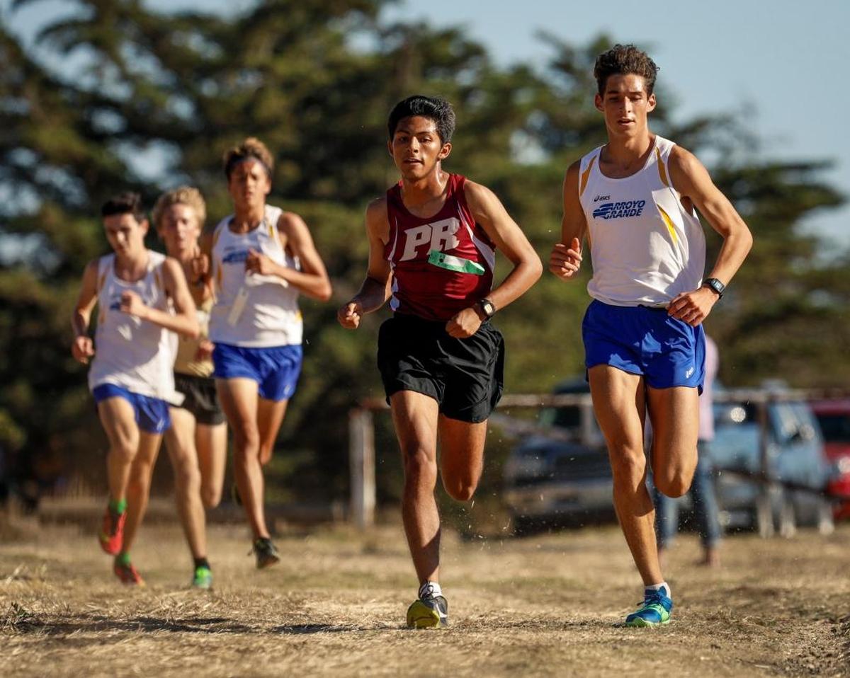Paso Robles junior Pablo Cortes battles Arroyo Grande senior Luis Jazo at the San Luis Obispo County cross country meet at Laguna Lake Park.