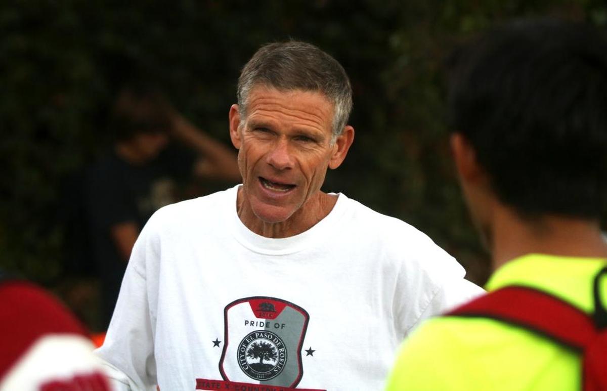 Paso Robles High School cross country and track and field coach Ivan Huff addresses the boys cross country team before it departs for the CIF-Southern Section Prelims in Riverside.