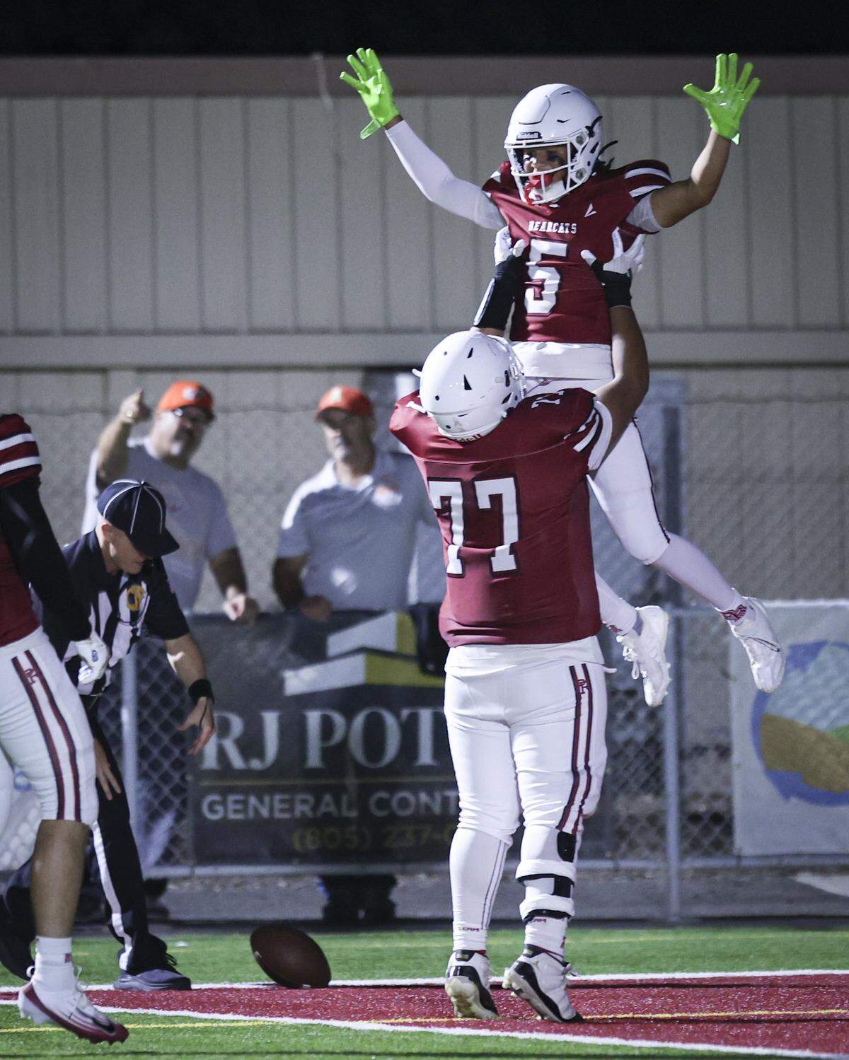Aloissy Garcia holds up Tre Clark after a touchdown. Paso Robles beat Atascadero 49-14 on Sept. 19, 2025.