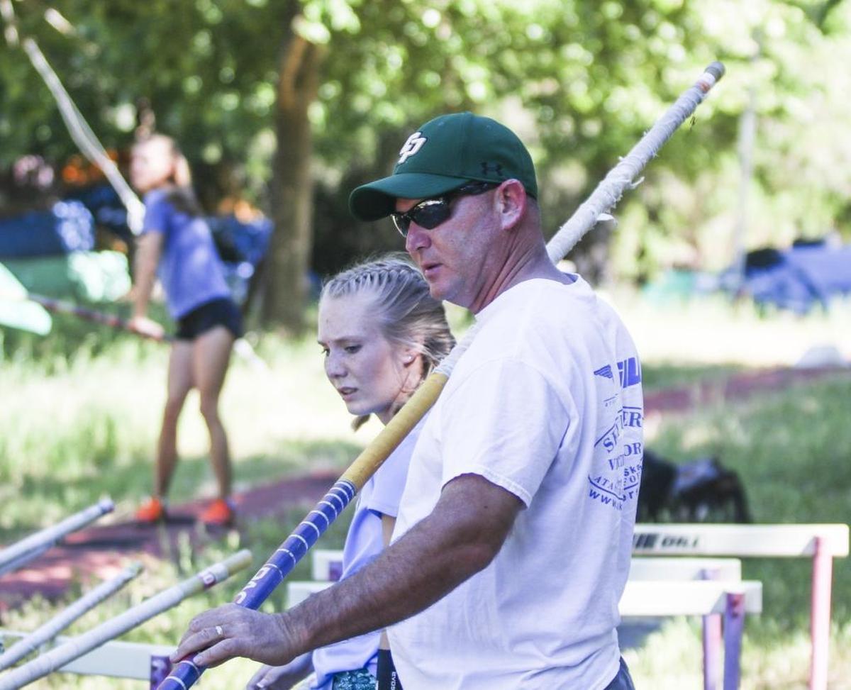 Jim Wilshusen and daughter Codie examine a pole during preparations for the CIF State Meet in Clovis.