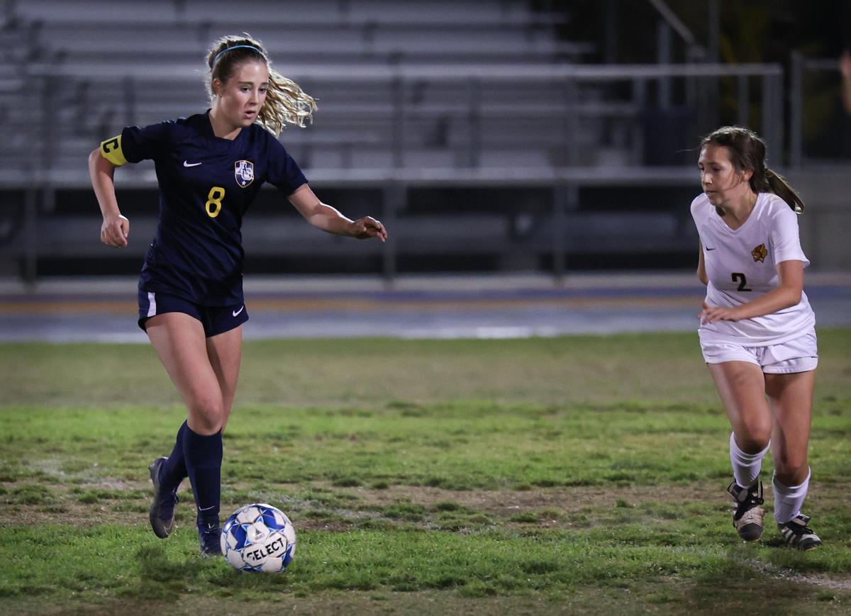 Katherine Parker of Arroyo Grande makes a pass under pressure from #2 Tatiana Orozco of San Luis Obispo. Arroyo Grande won in an overtime shootout against San Luis Obispo in girl’s soccer Feb. 11, 2022.