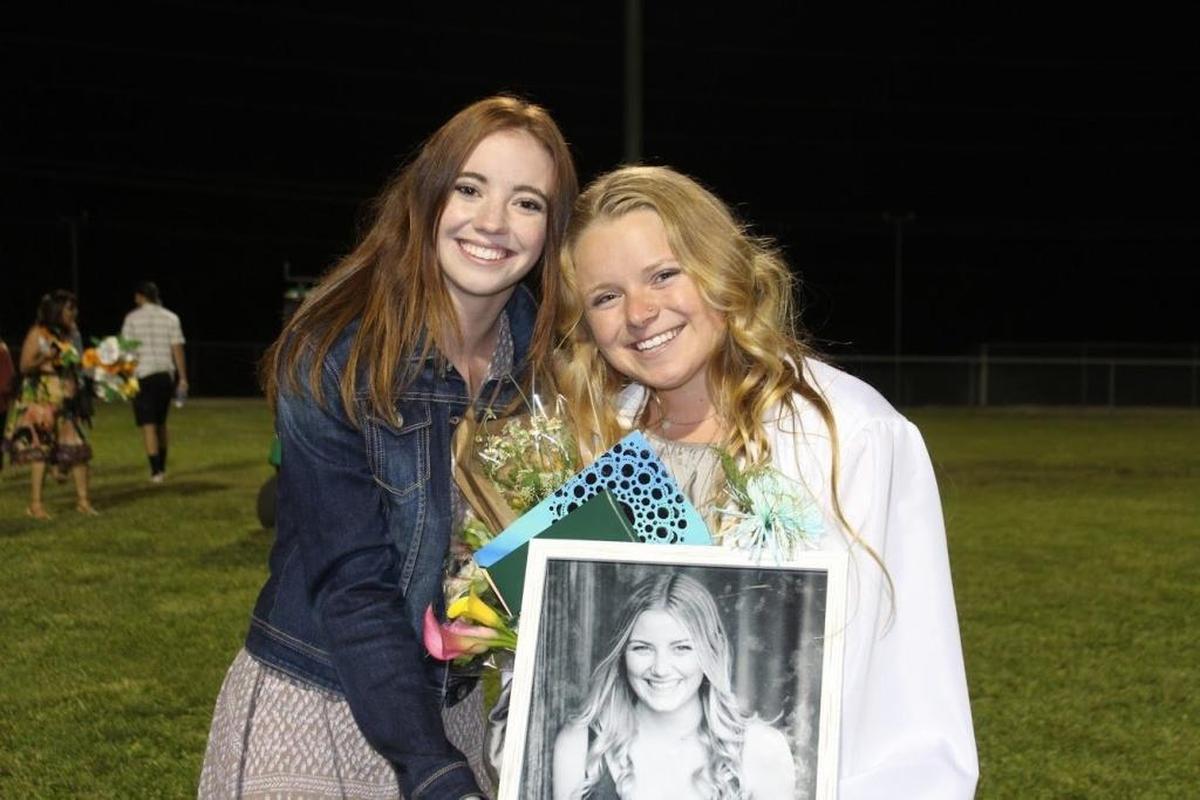 Amanda Wilson (right) holds a photo of Shelby Sudbrink along with Shelby’s sister, Hailey, on Templeton High School’s graduation night.