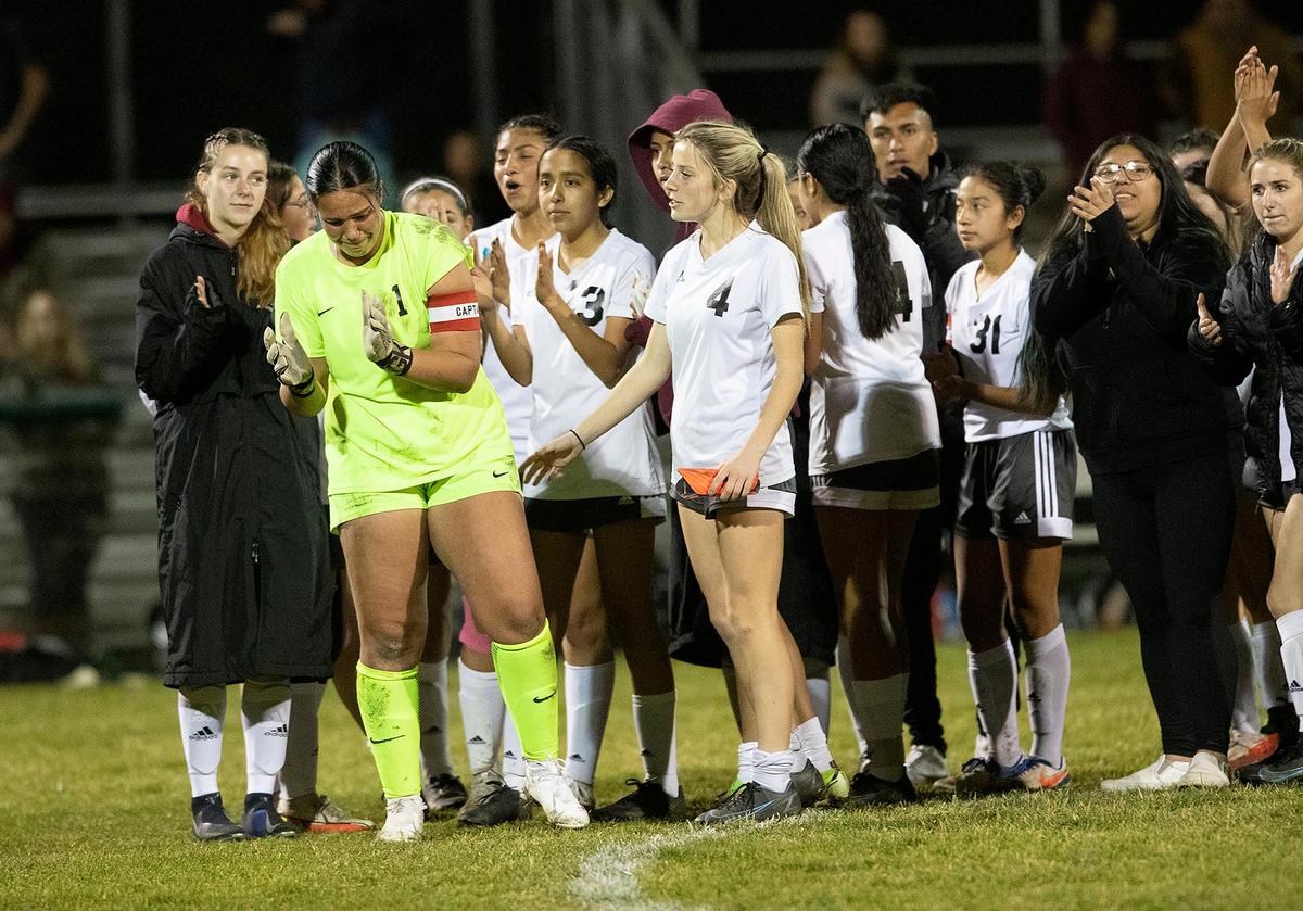 Templeton High School girls soccer team beat Nipomo High School in sudden death. Nipomo goalkeeper Alexis Acosta (1) shows emotion as her team cheers Templeton and her teammates comfort her.