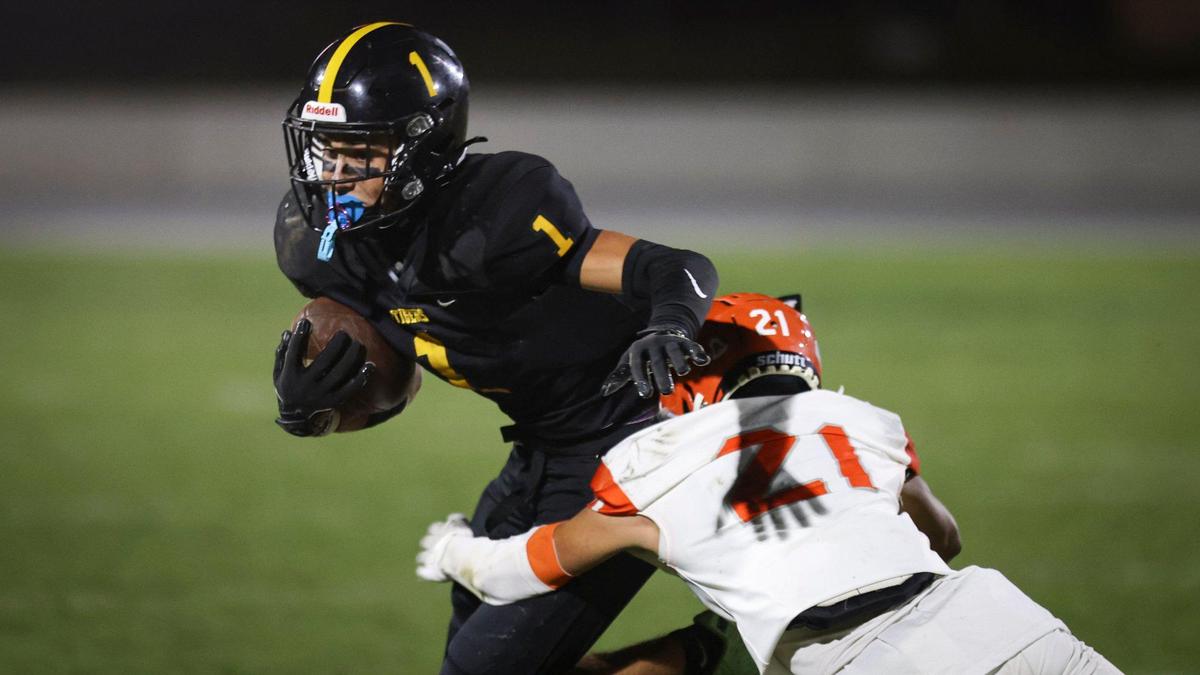 Cody Johnson runs after a catch and is tackled by Tony Kreider as San Luis Obispo beat Atascadero 35-0 to win the Sunset League title in a high school football game on Nov. 1, 2024.
