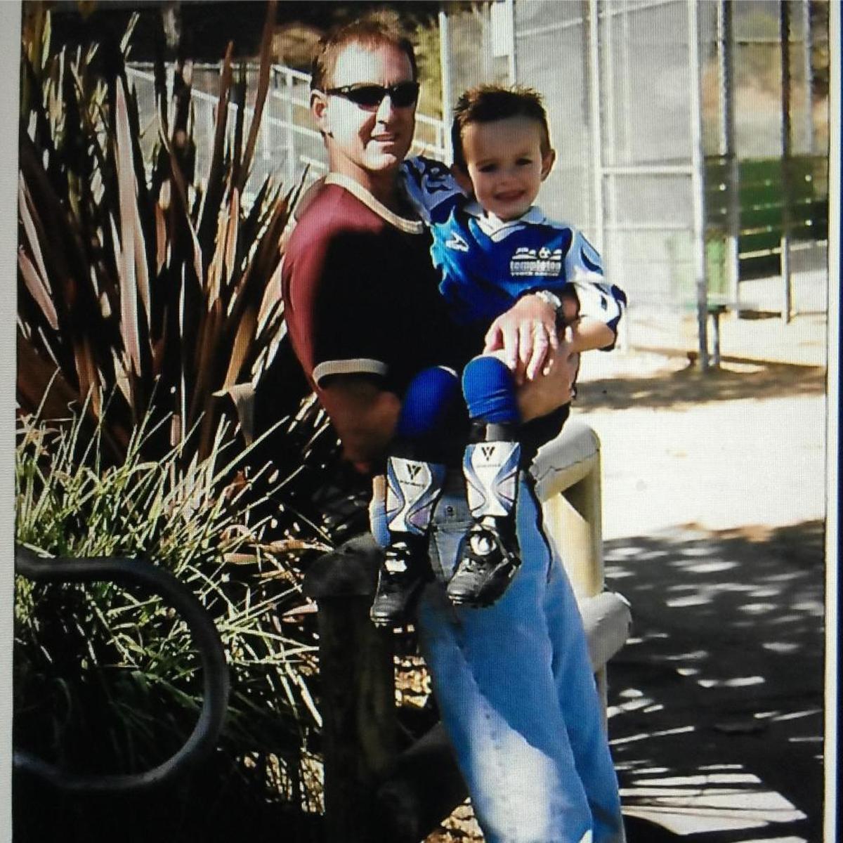 Colby Grey as a child held by his late father Steve Grey.