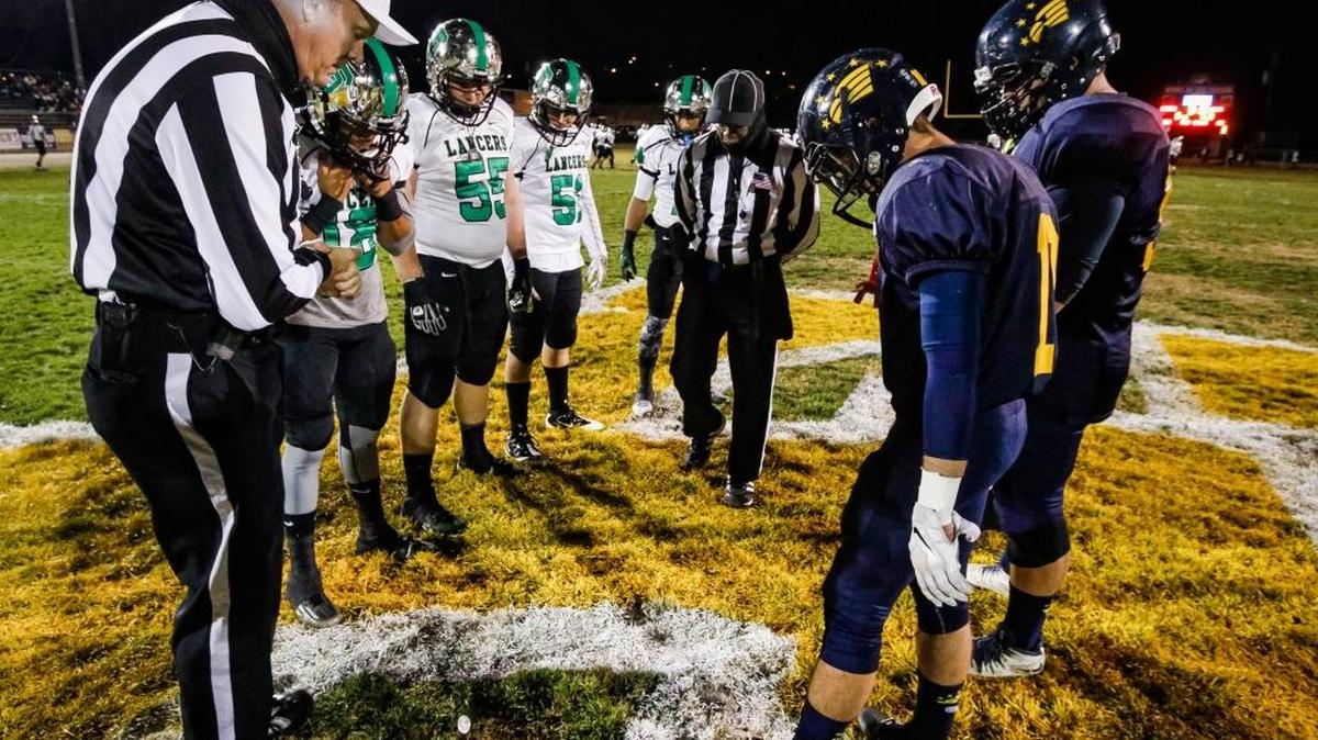 Arroyo Grande High School football players (right) line up against players from Thousand Oaks for the pregame coin toss before a Nov. 27 playoff game.