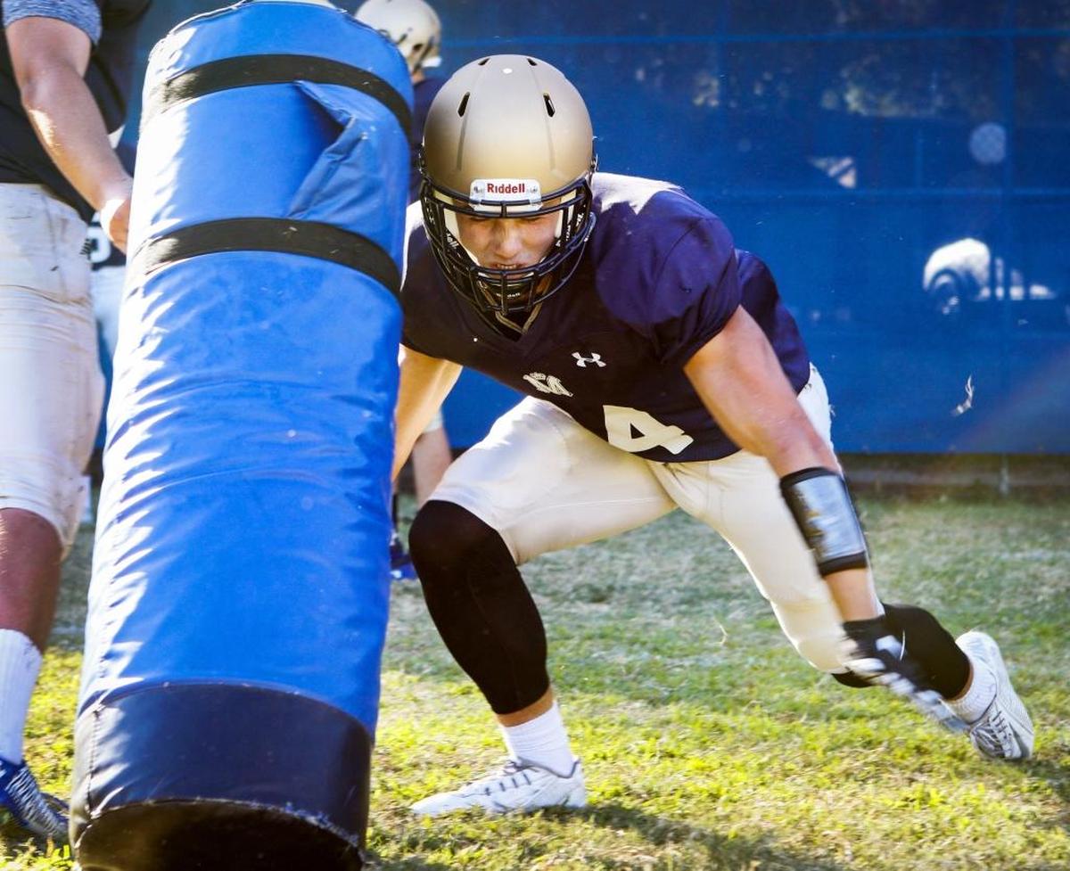 Patrick Miller hits a tackling dummy during a Mission Prep football practice.