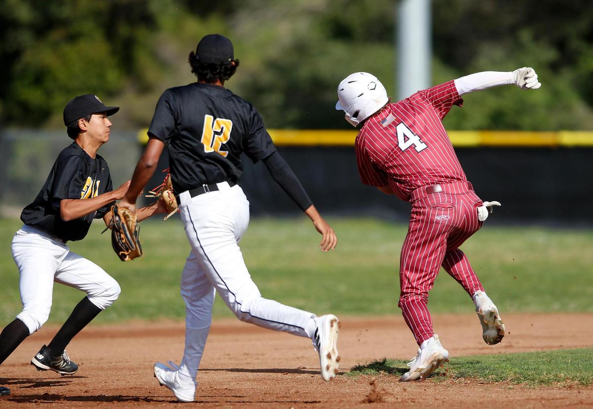 San Luis Obispo’s infielder Daniel Bush (20) makes a tag on Paso Robles’ Bryson Hoier (20) after a rundown by Alek Naran (12). San Luis Obispo Tigers beat Paso Robles High school at Taylor Field in San Luis Obispo on Friday.