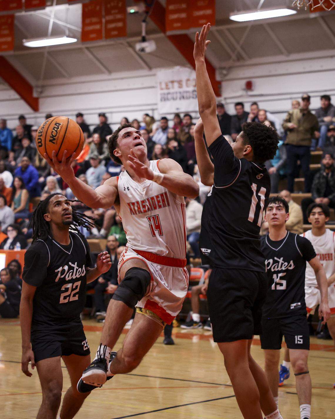 Damon Mitchell drives between Michael Harris and Justice Bell. Atascadero beat Hoover 69-52 to advance to the final game in the Division II CIF Central Section Boys Basketball Championships.