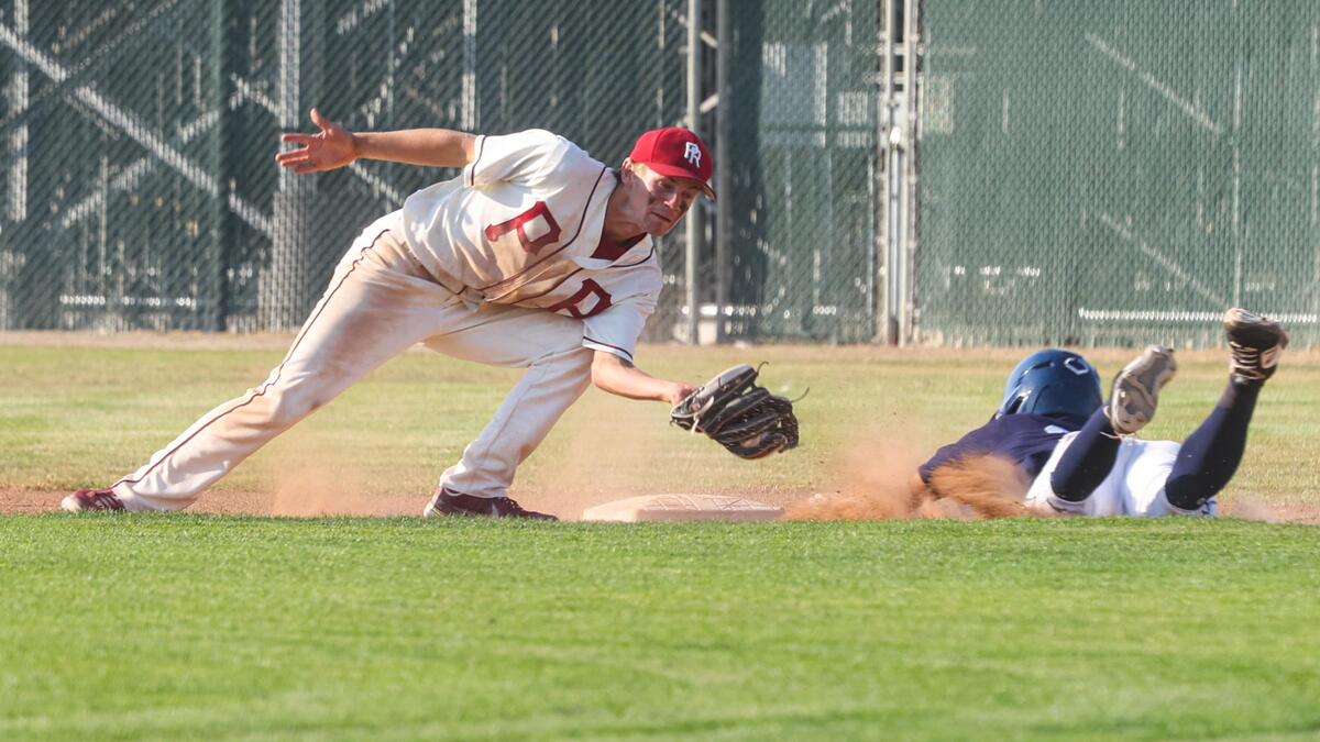 Kaden Tynes was tagged out by Kolby Gidcumb while attempting to steal second base. Arroyo Grande hosted Paso Robles in a playoff baseball game in the delayed COVID-19 season. Both schools have graduated.