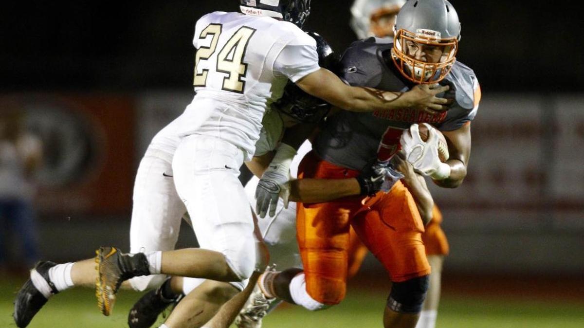 Atascadero High’s Marc Martin tries to break the tackle of San Luis Obispo’s Cristino Sandoval during Friday night’s game in Atascadero.