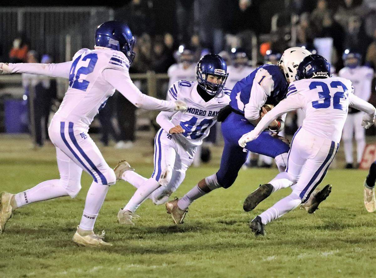 Morro Bay players Manny Diaz (42), Mason Hoag (40) and Shawn Shaffer (32) try to bring down Fall River’s Evan Dobson in the Division 7-AA state championship at Fall River on Saturday, Dec. 11, 2021. Fall River won the state title 43-13.