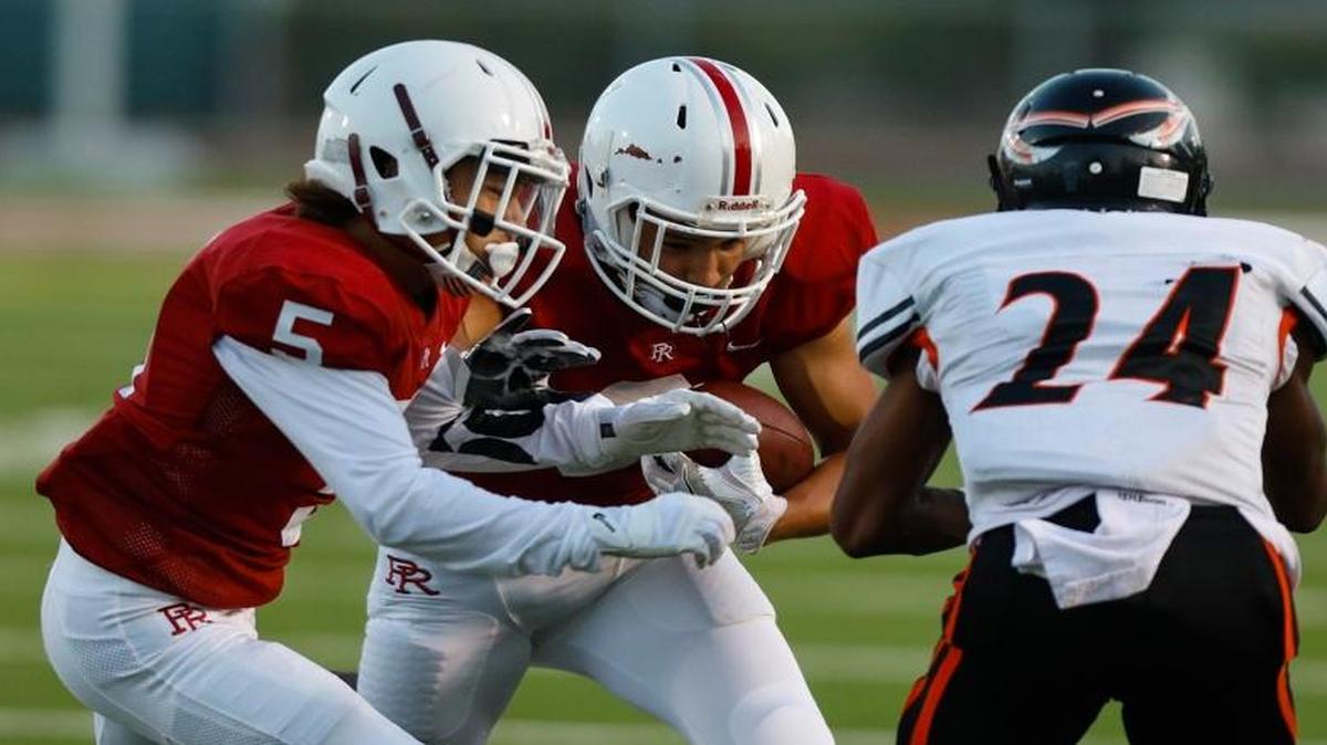 Paso Robles High senior running back Julian Madrigal carries the ball while senior Daede Murphy goes for the block in a nonconference game earlier this season against McClymonds.