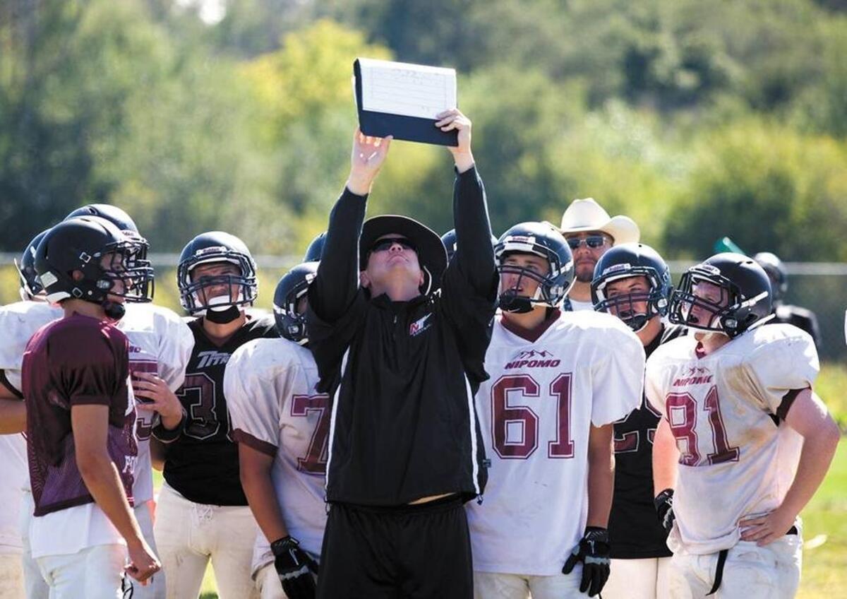 Nipomo High athletic director Russ Edwards goes over a play with the Titans football team in a 2012 practice.