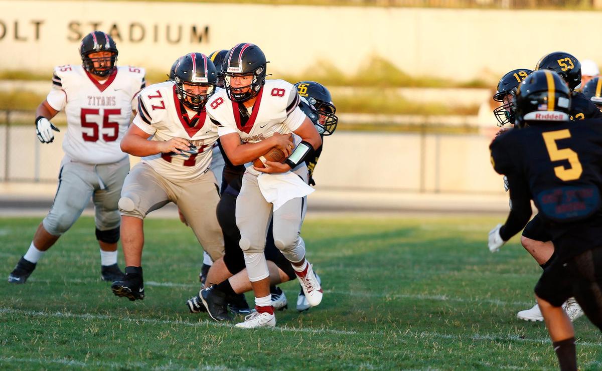 Nipomo quarterback Griffin Groshart (8) dodges defenders. San Luis Obispo beat Nipomo 38-7 in a nonleague game at San Luis Obispo High School’s Holt Field stadium, Aug. 18, 2023.