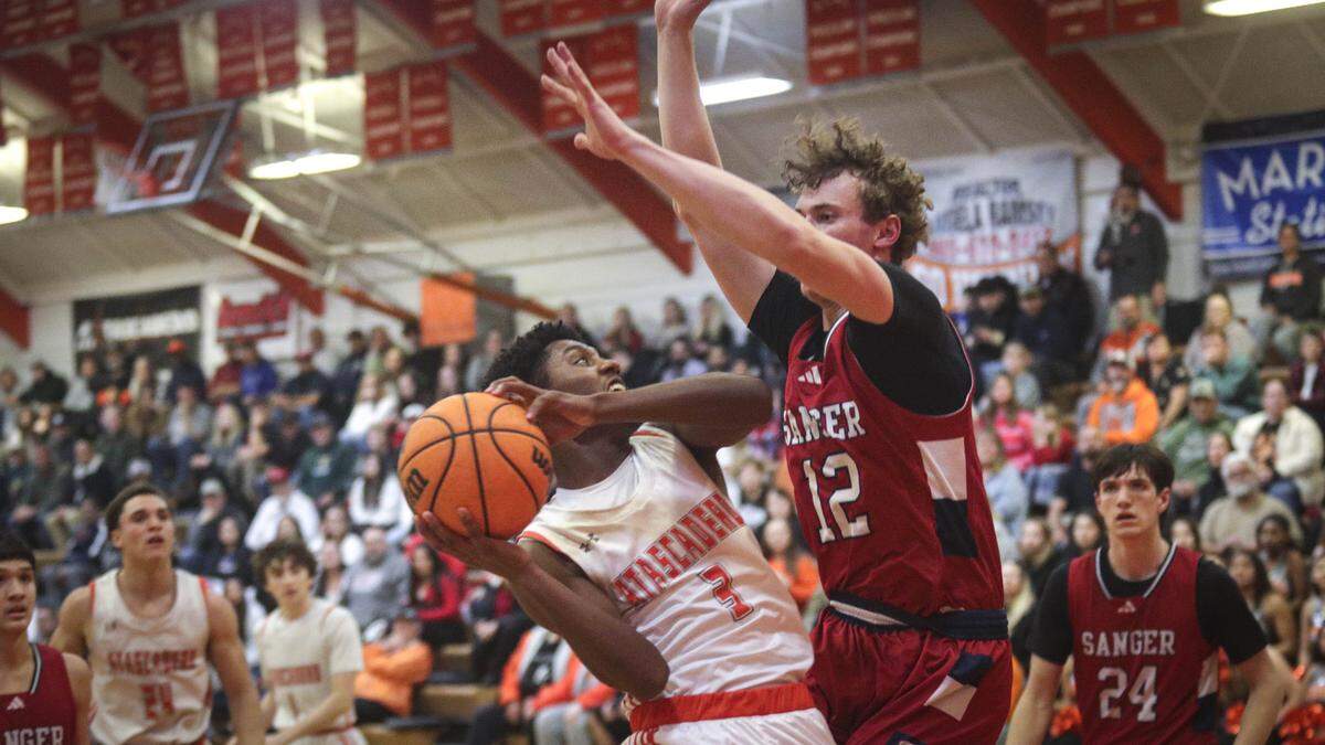 Shea Buckley shoots under pressure from Caleb Delong. Atascadero beat Sanger 82-41 in a basketball playoff Feb. 17, 2026.